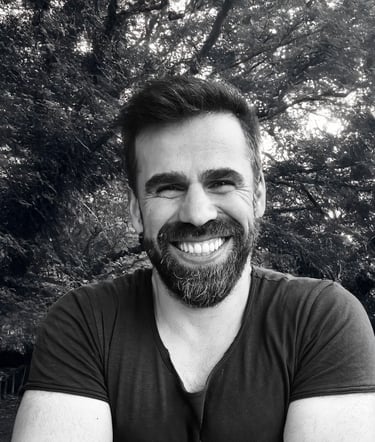 Adnan Erzen, Tai Ji and Qi Gong instructor at WDP Türkiye, smiling outdoors in a forest setting.