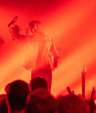 a man in a white shirt and a microphone in front of a red light