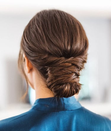 A bride wearing her hair in a low effortless bun with twists