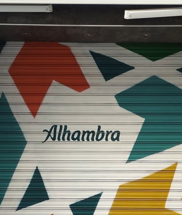 Graffiti corporativo Cervezas Alhambra en cierre metálico de restaurante MadreSelva en Sevilla