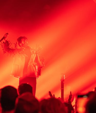 a man in a white shirt and a microphone in front of a red light