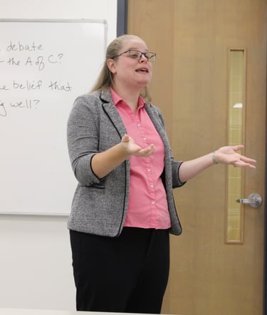 Dr. Hooton at the front of a classroom lecturing during a US History survey course.