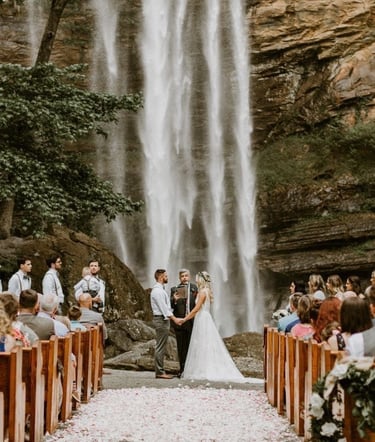 bride and groom reciting vows in front of a waterfall destination wedding