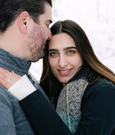 a man and woman standing in the snow
