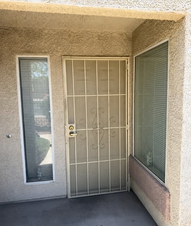 Front door of condo without solar screens on its two front windows.