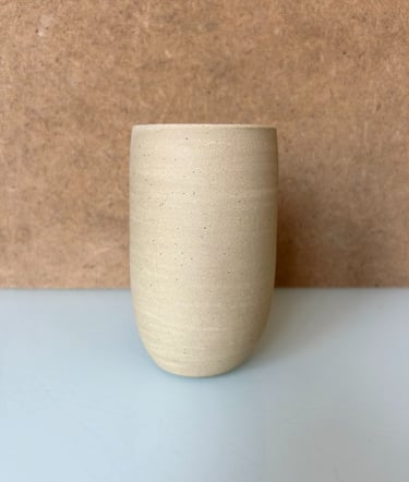 a small vase with a white vase on a table