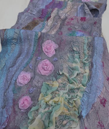 Handmade nuno felted scarf featuring textured silk ruffles and 3D pink rose fiber art details.