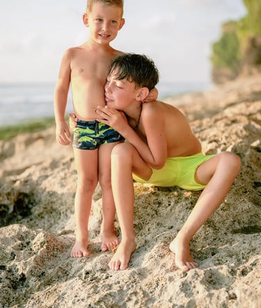 Mother sharing a quiet moment with her son on the cliffs of Dreamland Beach Bali during a family photo session.