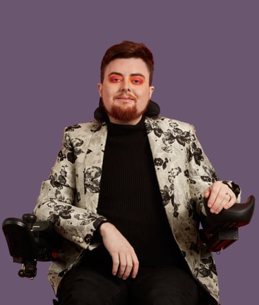 Jamie Hale, a white electric wheelchair user wearing a silver floral jacket