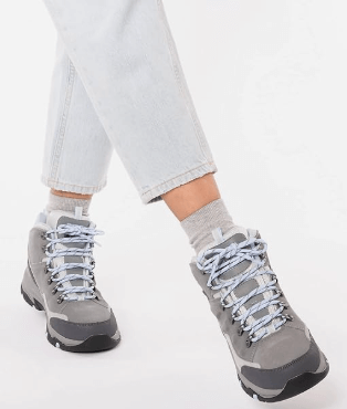 a woman's feet in grey shoes with laces