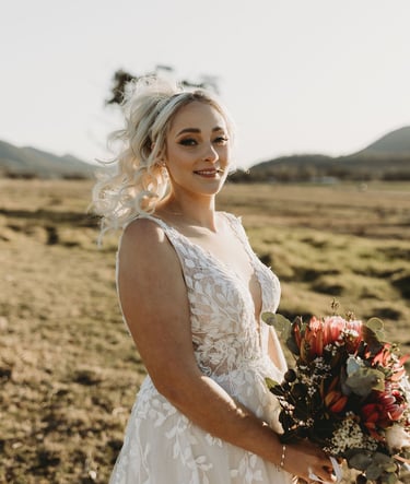 a woman in a wedding dress standing in a field
