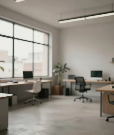 Spontaneous, cinematic wide shot of a creative studio in São Paulo. Large windows, minimalist furniture, and a focused atmosphere. Tones of #9A9E96 and #C1C4BF predominate with professional, natural lighting.