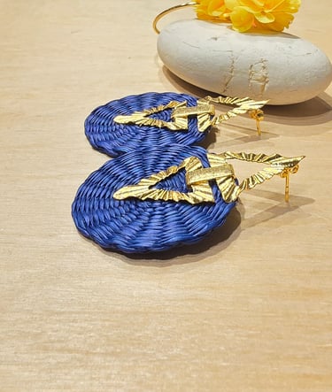 a pair of earrings with gold leaf earrings