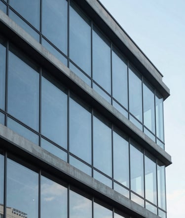 Clean, minimalist architectural photography of a contemporary office building in São Paulo, with large glass windows reflecting a serene baby blue sky. The composition is geometric and sharp, emphasizing professional elegance.