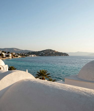 Panoramic view of the Bodrum coastline at golden hour, Middle Eastern / Turkish architectural elements, turquoise sea, bright clear sky, clean composition, professional landscape photography with soft grey and off-white tones.