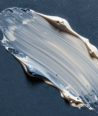 Macro photography of thick, textured oil paint on a canvas, focused on a palette knife stroke that blends dark slate blue and off-white colors, dramatic side lighting highlighting the ridges and valleys of the material.