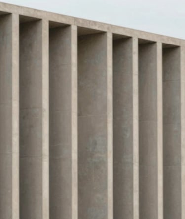 A minimalist, large-scale shot of a building facade featuring clean vertical concrete columns in #D9D2C7 sand tones against a clear, soft sky. Sophisticated architectural photography with precise symmetry.