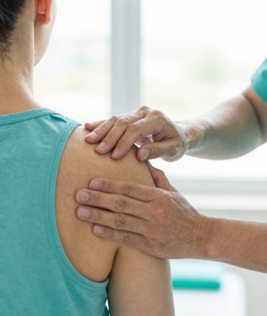 Close-up of a physiotherapist's hands performing precise joint mobilization on a patient's shoulder, bright clinical setting, soft daylight
