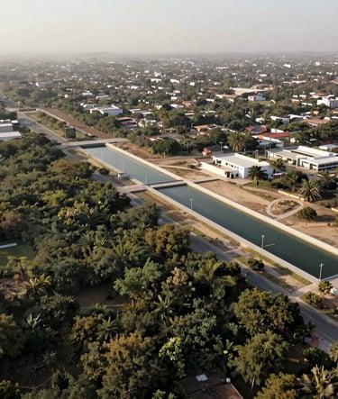 A wide aerial shot of a peri-urban landscape in Mexico featuring integrated water governance infrastructure. Muted olive green vegetation, warm beige soil, and clean architectural lines. Soft morning light, documentary style.