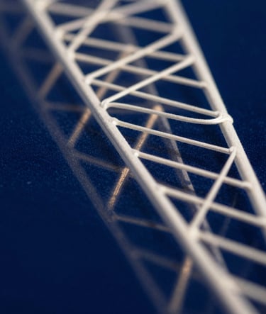 An artistic macro photograph of delicate, geometric light patterns reflecting off a dark surface. The composition uses Deep Prussian Blue and Soft Off-White to suggest a bridge between computational logic and organic beauty. High contrast and precise focus.