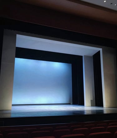 A wide photography shot of a professional theater stage in the US, featuring a modern set design with clean lines and muted blue lighting, sophisticated and contemporary atmosphere.
