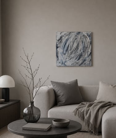Modern minimalist living room featuring a neutral sofa, abstract wall art, and a designer table lamp.