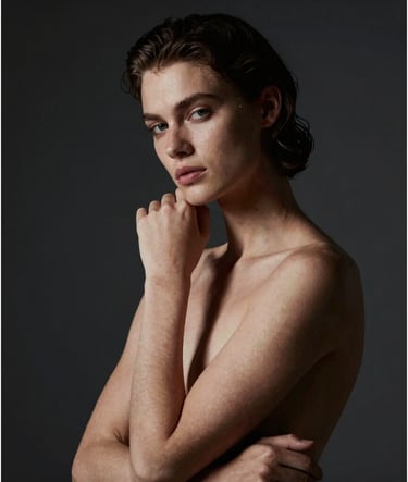 Artistic video still featuring a model in a Renaissance-style pose. Chiaroscuro lighting creates a dramatic effect with light hitting only half of the face. The background is a dark charcoal (#363131), while skin tones are warm and sandy (#D5BFB3). Sophisticated and professional artistic photography style.