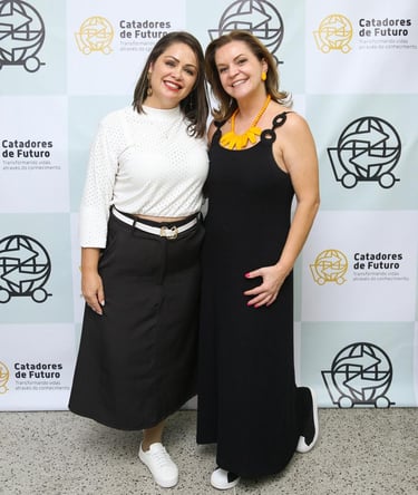 two women standing next to each other in front of a wall with a sign that