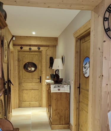 Intérieur d'un chalet dont les portes sont décorées de médaillons en trompe-l'oeil, thème jurassien.