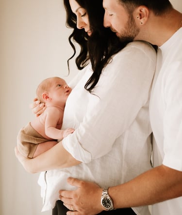 couple holding newborn baby where baby bump was, in studio Adelaide Hills 