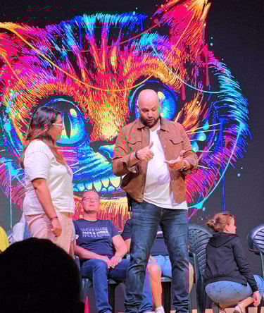 a man and woman on stage with a cat