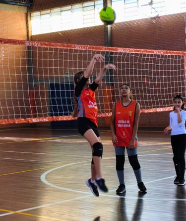 Aluna da escolinha de vôlei treinando saque durante aula no Centro Poliesportivo Aviva, em Caxias do
