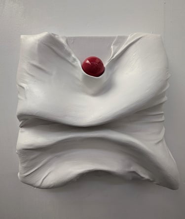 a red sphere sitting on top of plastered fabric