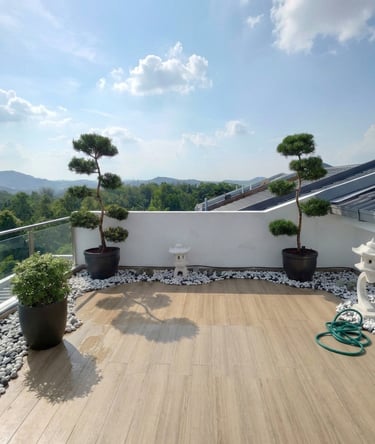 Rooftop Zen garden design in Rawang with decorative bonsai, white pebbles, and stone pagodas.
