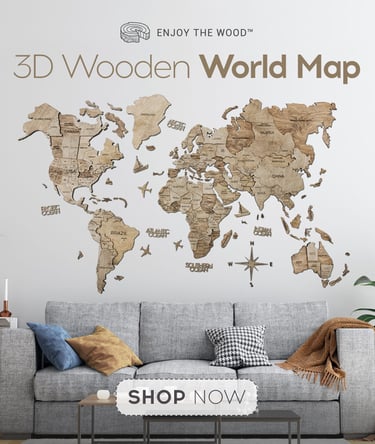 Mapa mundial 3D de madera como decoración de pared, colocado sobre un sofá moderno gris.