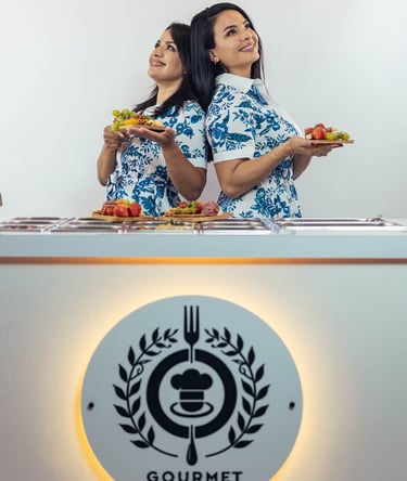two women standing in front of a counter top