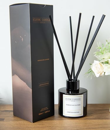 Oakmoss & Cedarwood Reed Dia black and white diffuser with a black box and a white vase with flowers