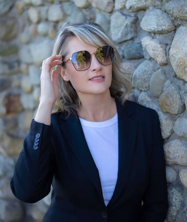 a woman in a black suit and sunglasses