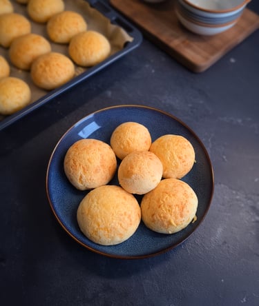 Bol de petits pains au fromage brésiliens dorés (pao de queijo) moelleux, servis tièdes