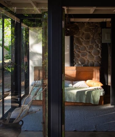living room with a couch and lots of windows on a beautiful stone wall