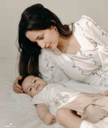 Mother cuddling baby on bed – Fred Art Studio family session