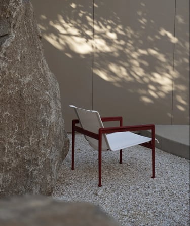 Outdoor lounge seating with armchairs, hanging chair, soft cushions and natural textures for relaxed
