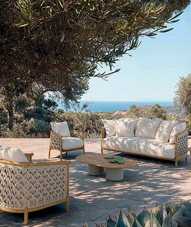Garden seating with outdoor performance fabric, synthetic wicker, stone surfaces and natural materia