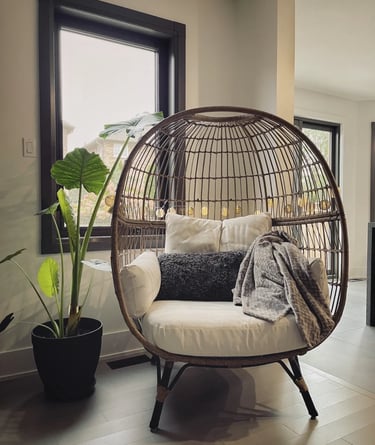 Cozy hanging lounge chair with soft cushions, warm lighting and natural textures for relaxed outdoor