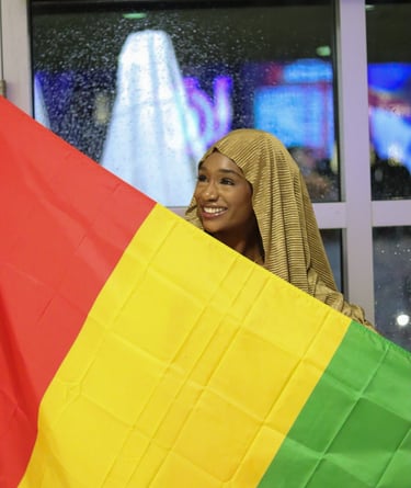 A woman holding a Guinea Flag for an event: Culture Show