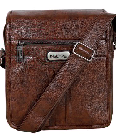 a brown leather sling bag with a silver metal buckle and silver slider