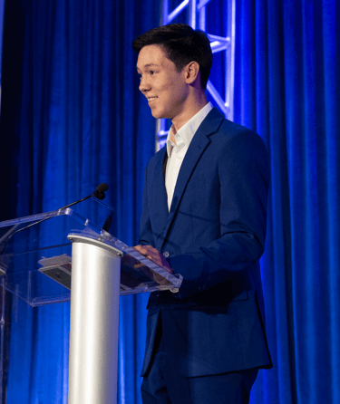 founder, Joseph Phelps in a suit and tie standing at a podium