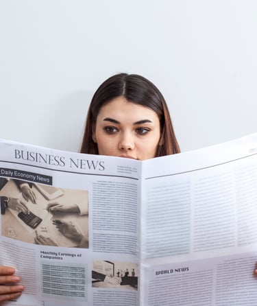 Femme tenant un journal et le regardant 