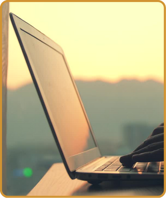 Image of copywriting and content creation on laptop with sunset and Colorado mountains in background