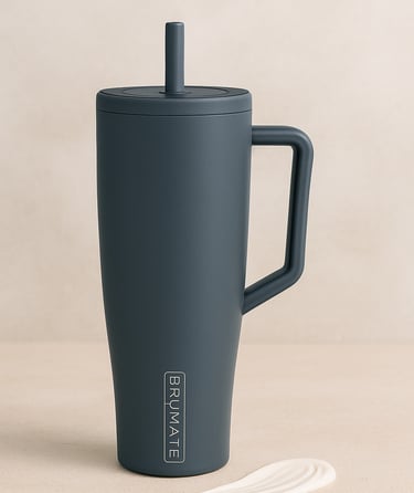 Dark gray tumbler with straw and handle on a neutral background